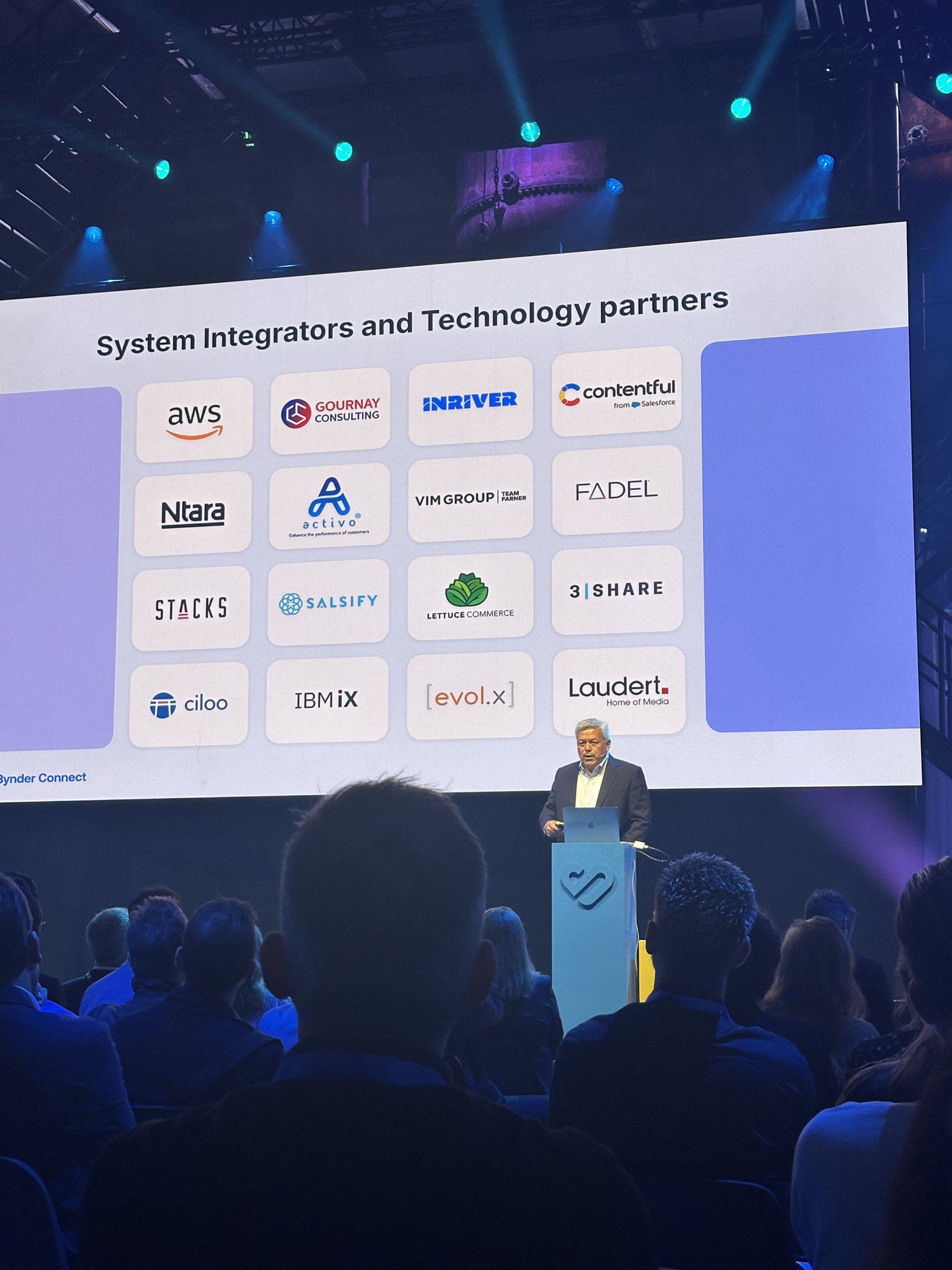 Bynder CEO Bob Hickey presents a Bynder Connect 2026 slide listing Bynder's system integrator and technology partners, including Stacks.